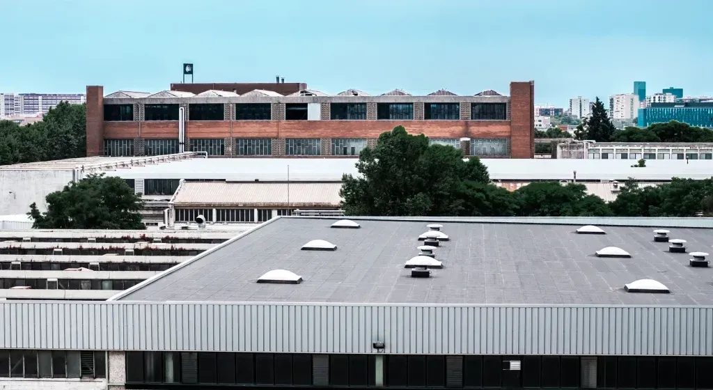 tpo roofing,tpo roofing services,tpo roofing services in austin,tpo roofing austini,Commercial TPO Roofing - HD Roofing And Repairs Roofs of industrial buildings against a light blue sky; a brick building is in the background.