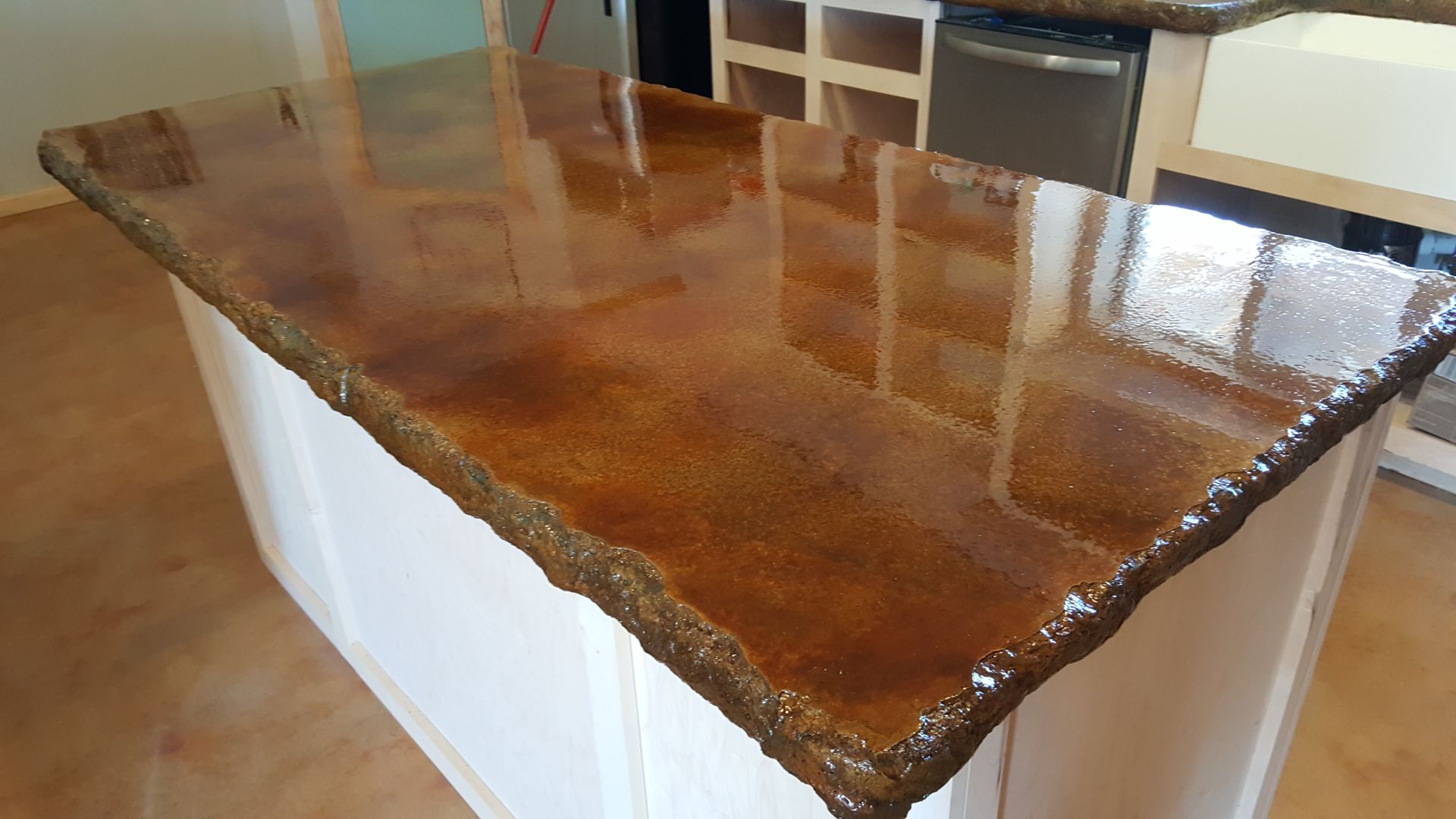 Glossy brown stone kitchen island countertop with white base