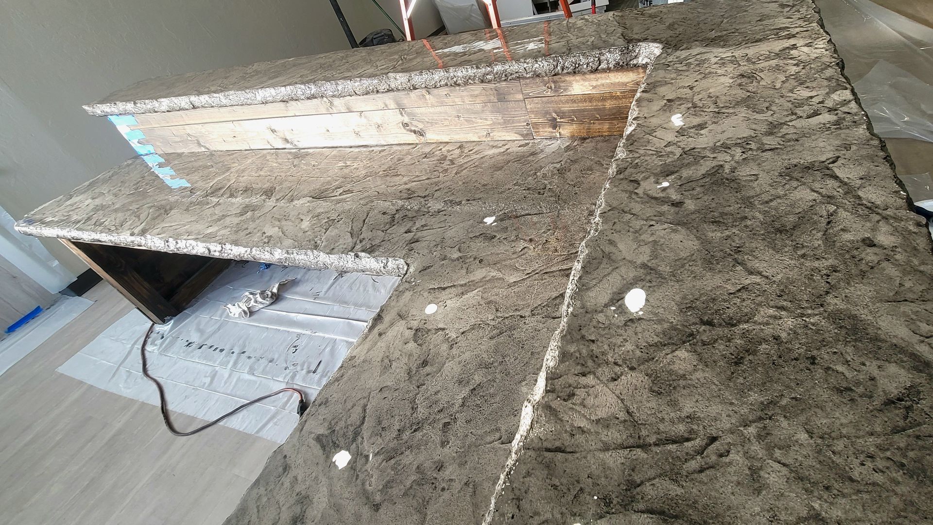 Granite kitchen countertop with a rectangular cutout and exposed wiring underneath during installation