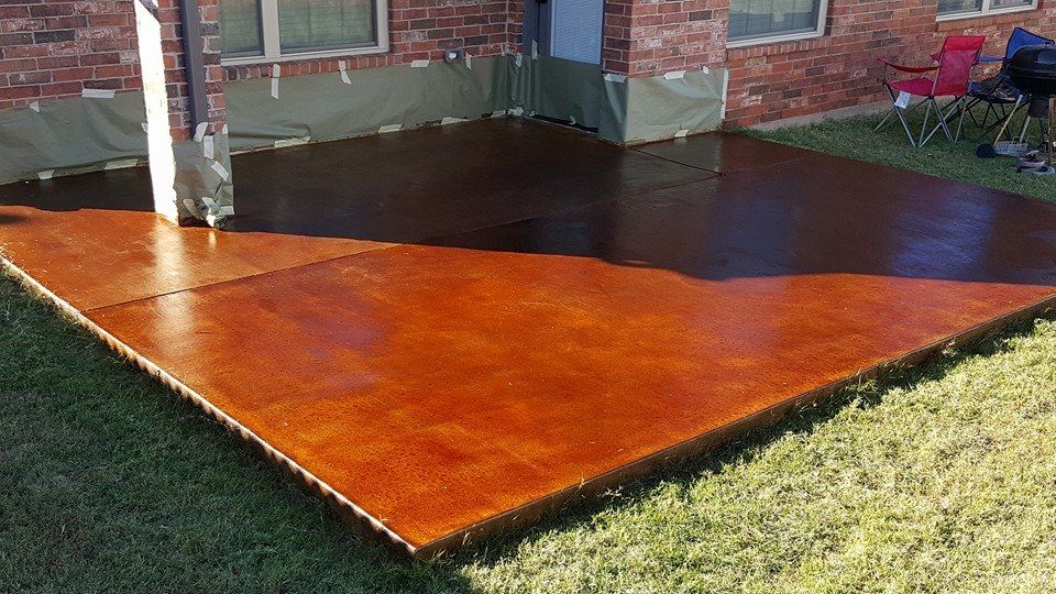 Freshly stained wooden patio deck beside a house and lawn