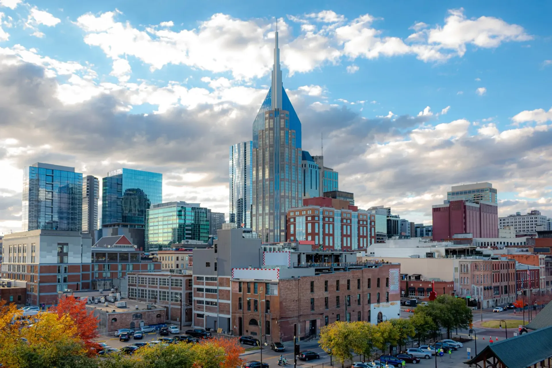 Nashville, Tennessee skyline with the Batman Building prominent, against a partly cloudy sky.