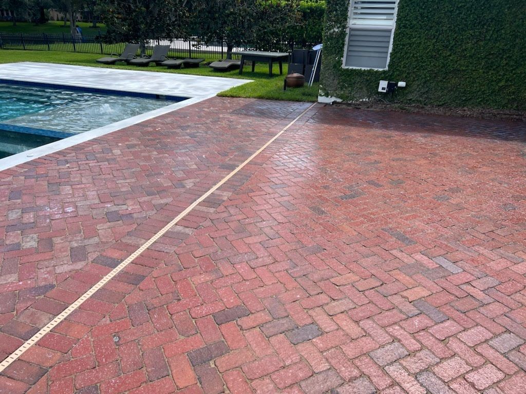 Brick patio next to a pool and ivy-covered wall.