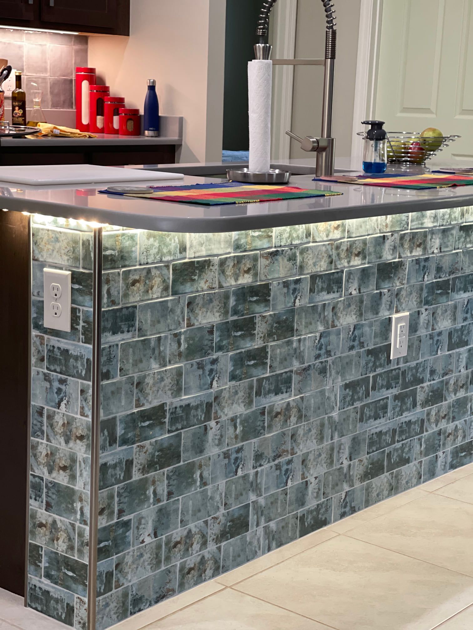 A kitchen with a brick counter top and a sink.