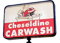 Sign for Cheseldine Carwash, a cartoon frog washes a car in a tub. Red and white text.