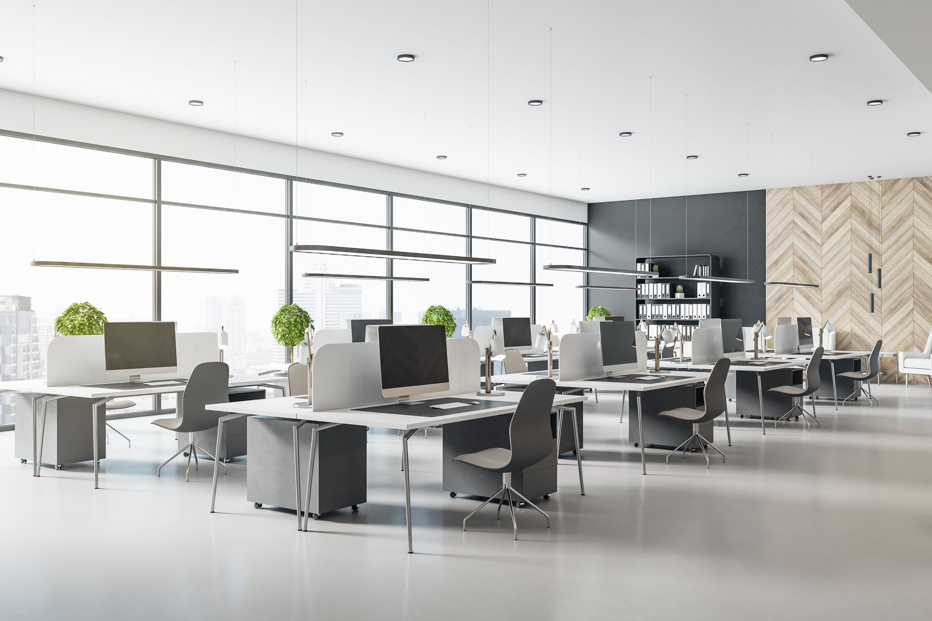 Modern open-plan office with desks, computers, chairs, large windows, and plants