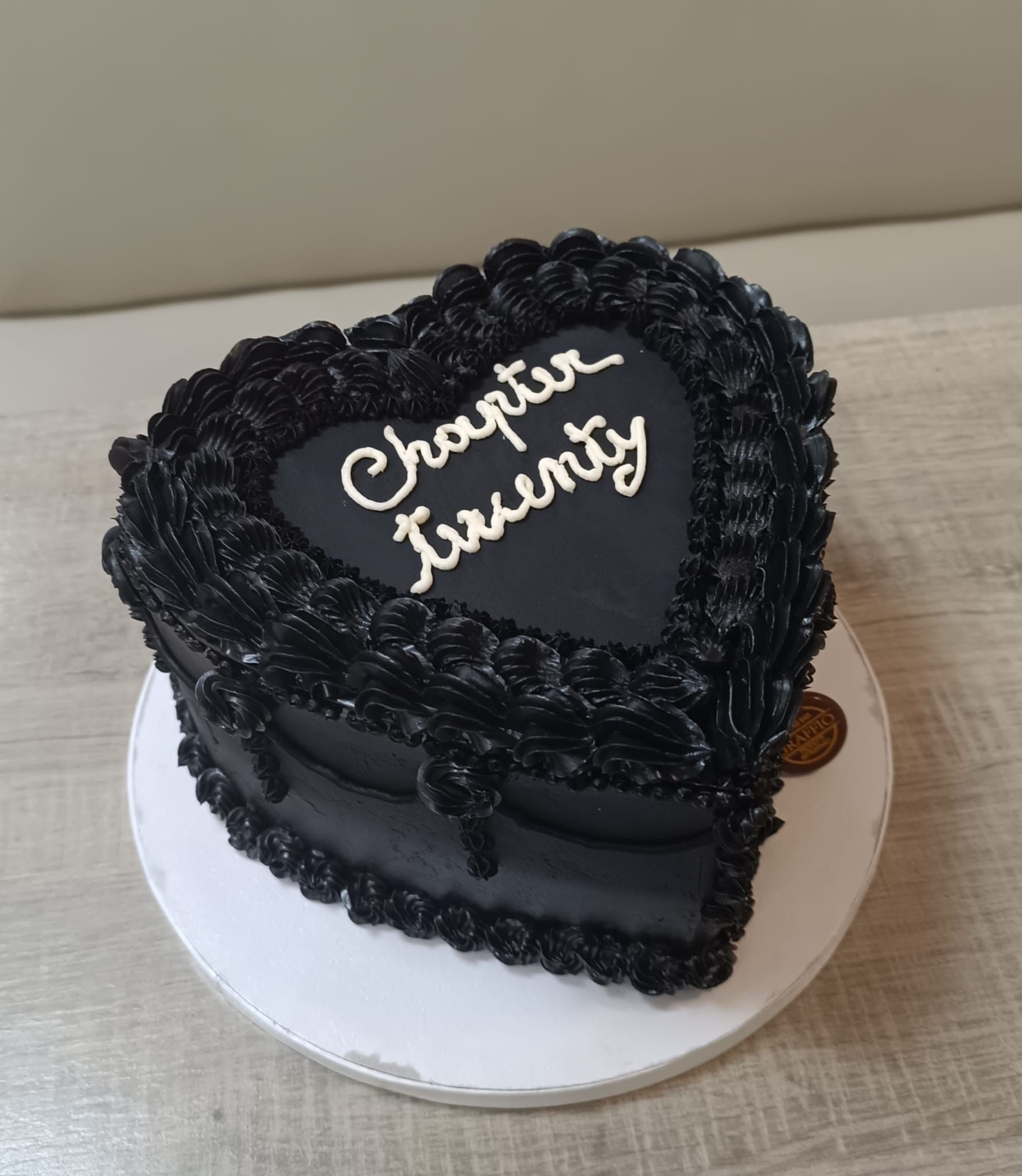 Torta nera a forma di cuore con la scritta
