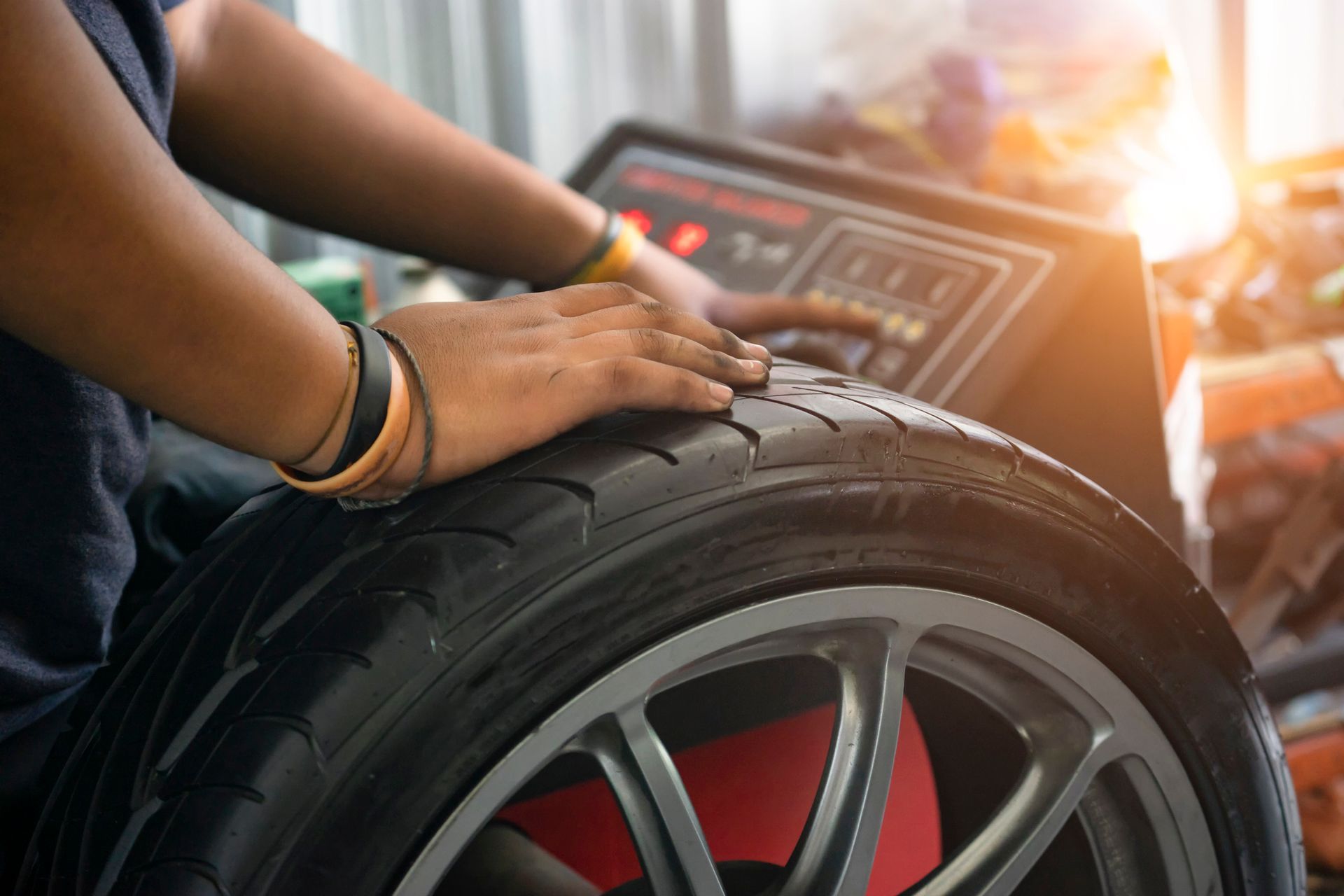 A man is working on a tire in a garage, demonstrating tire repair skills with tools nearby.