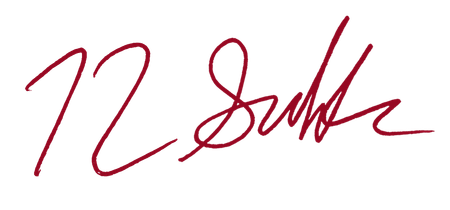 Red handwritten signature on a white background