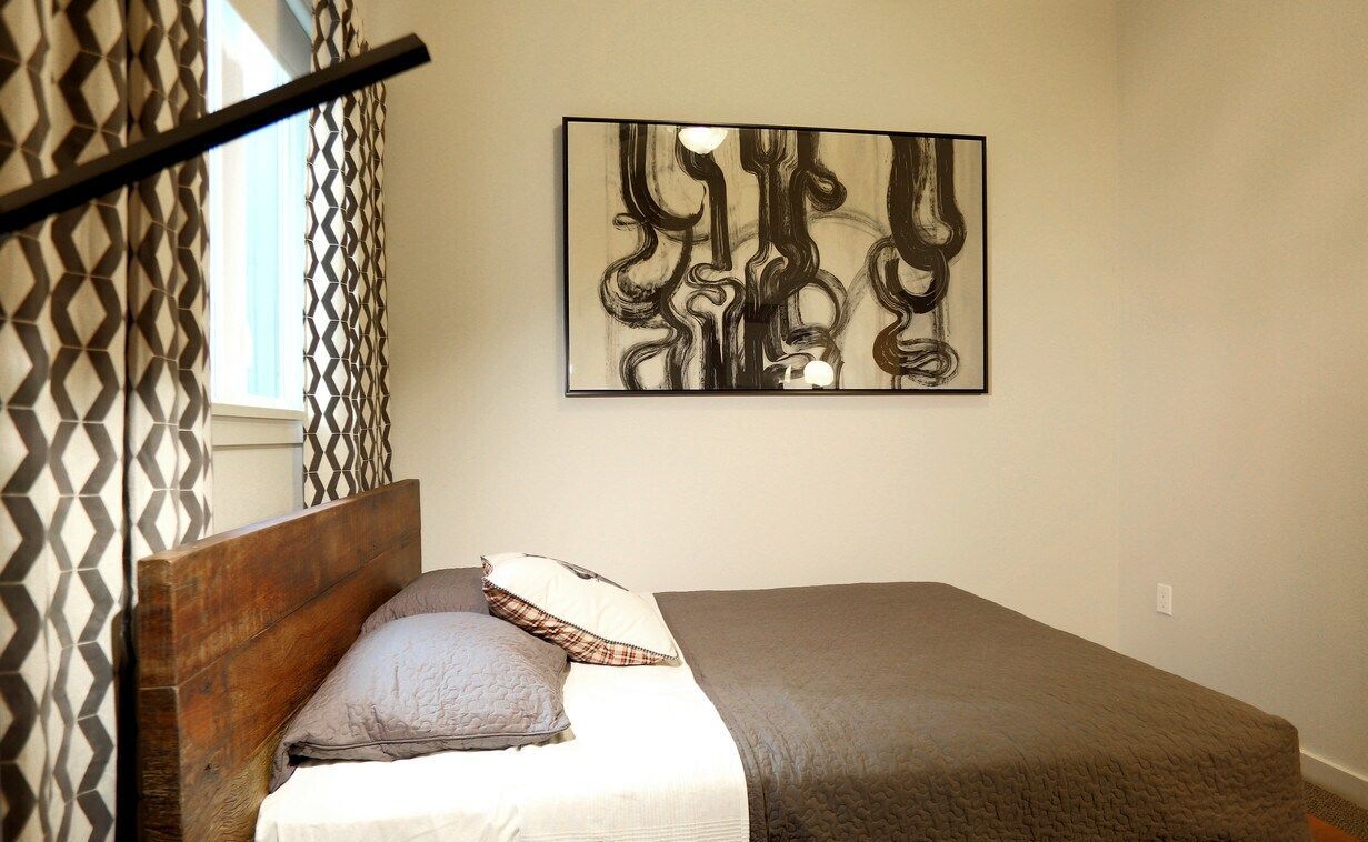A bedroom with a bed and a painting on the wall