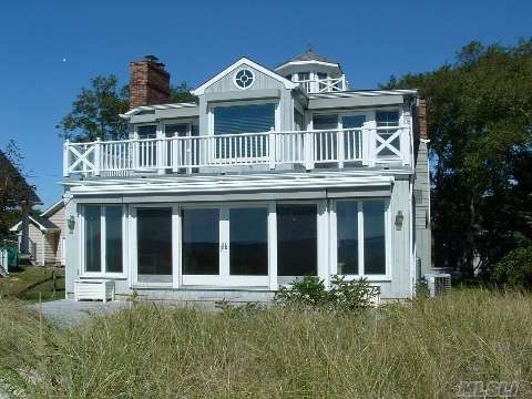 A large white house with a lot of windows and a balcony