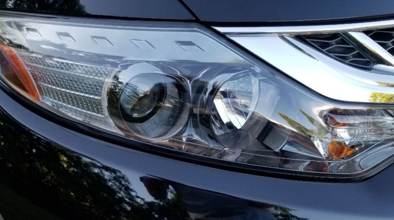 A close up of the headlight of a black car