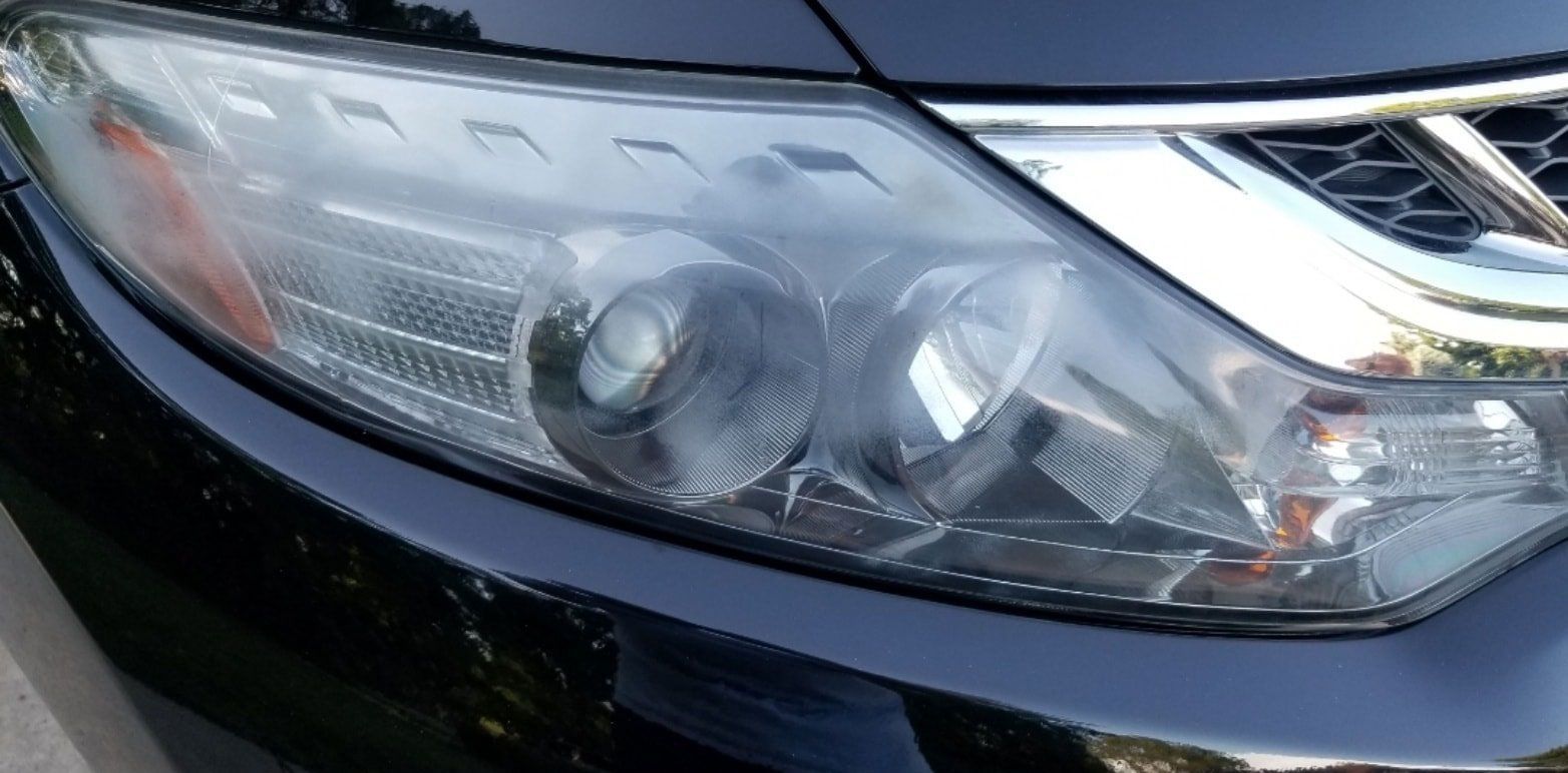 A close up of the headlight of a black car
