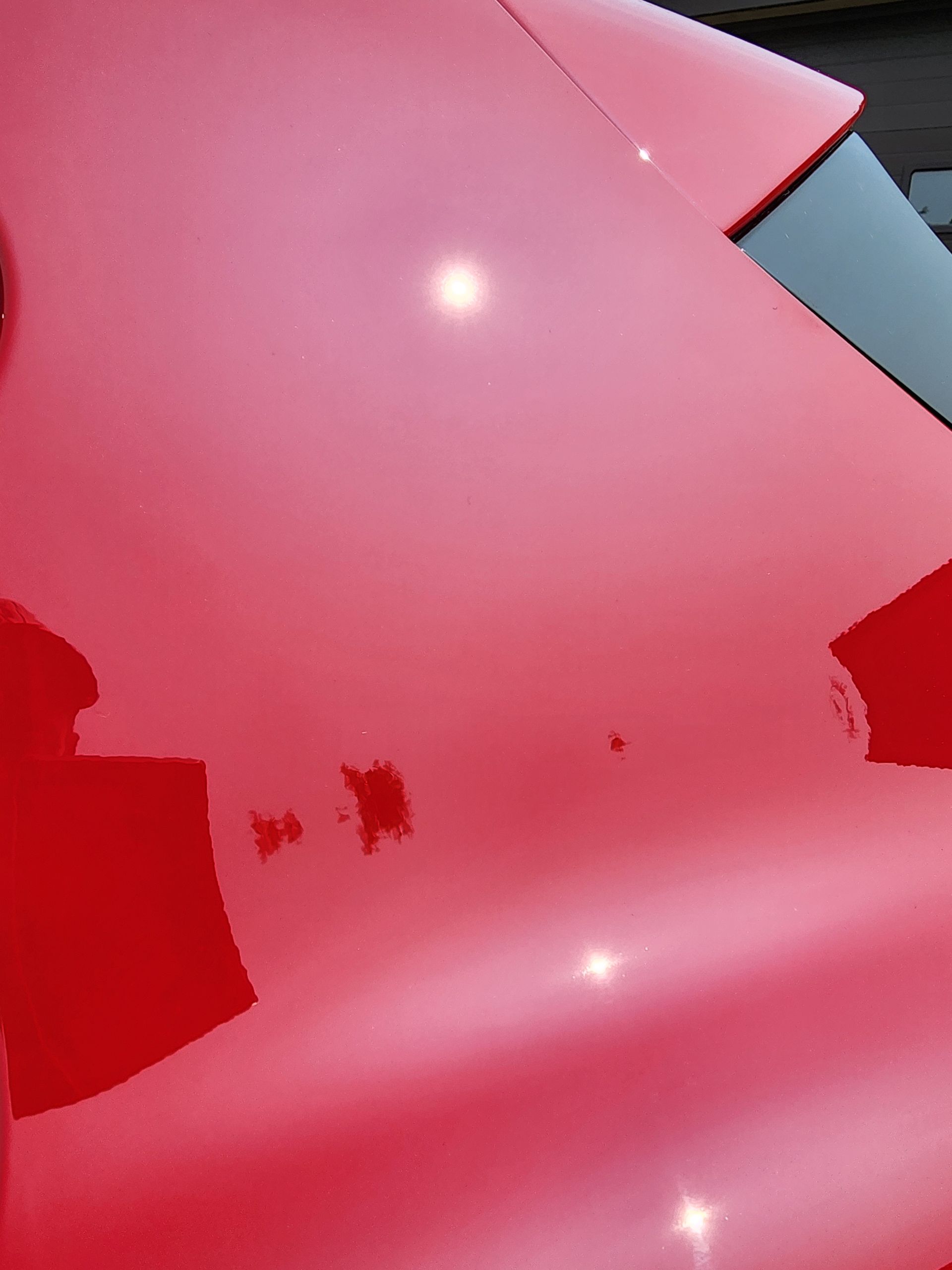 A close up of the hood of a red car