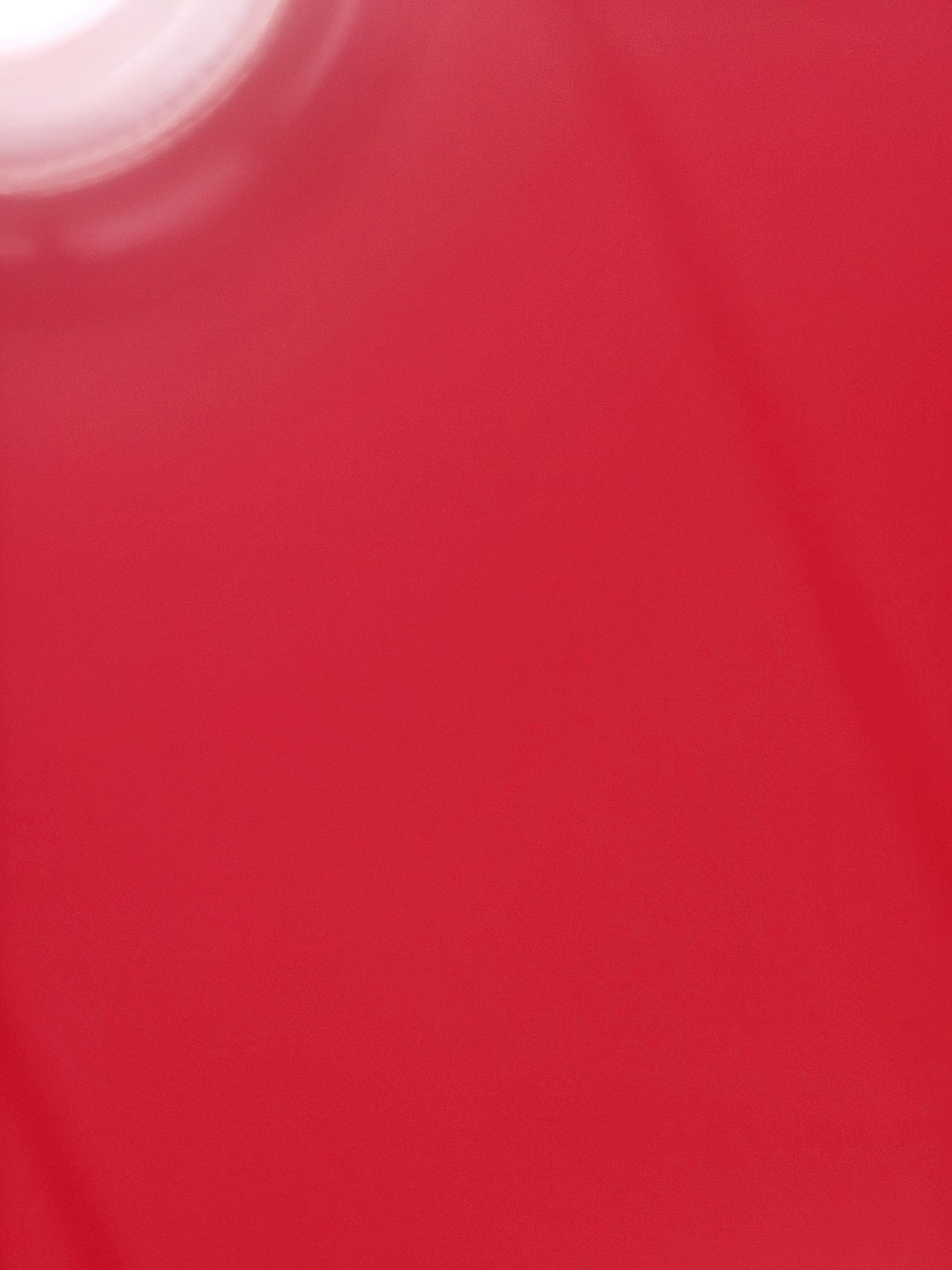 A close up of a red surface with a white circle in the middle.
