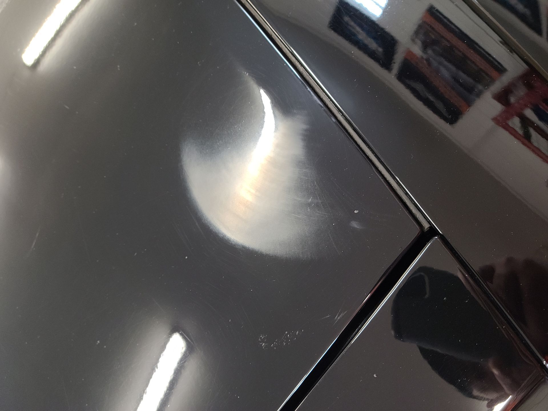 A black surface with a reflection of the moon