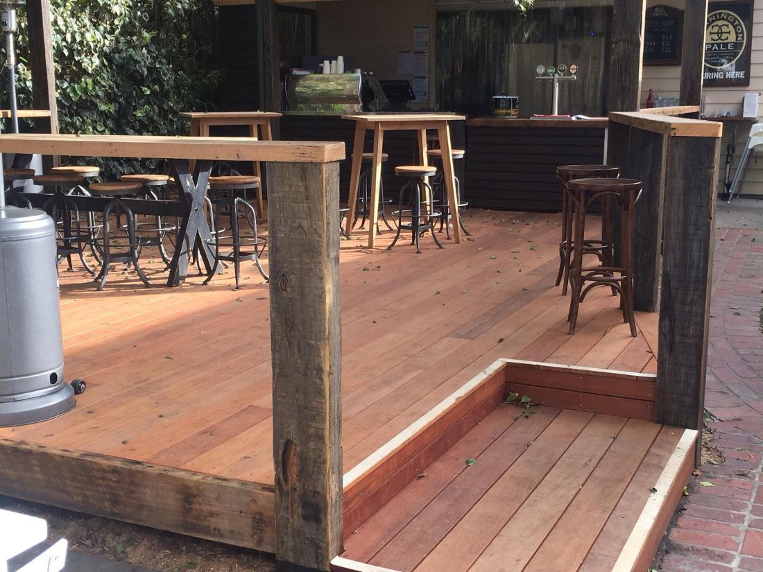 Outdoor Wooden Deck with Tables, Chairs, and A Railing — On The Rise Builders in Maroochydore, QLD