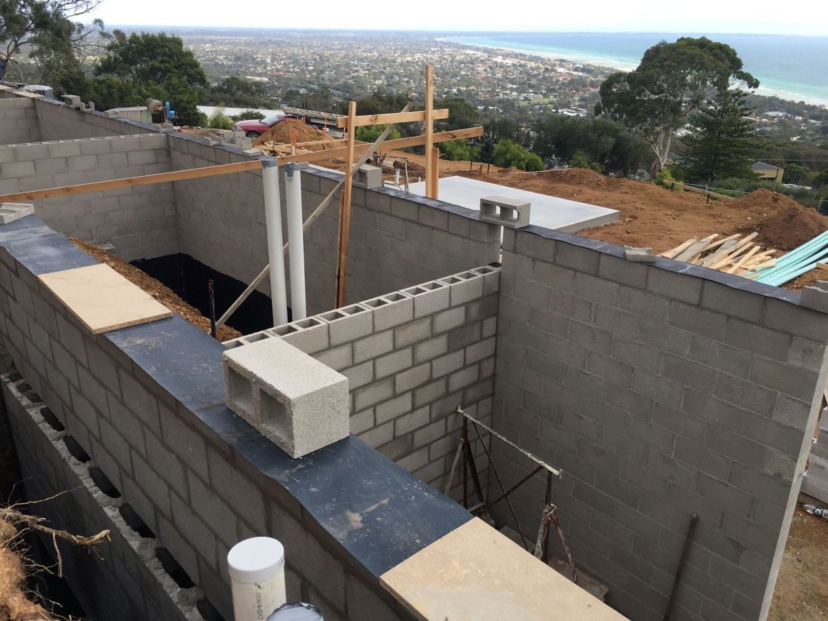 Construction Site with Cinder Block Walls Overlooking a Coastal City — On The Rise Builders in Noosa, QLD