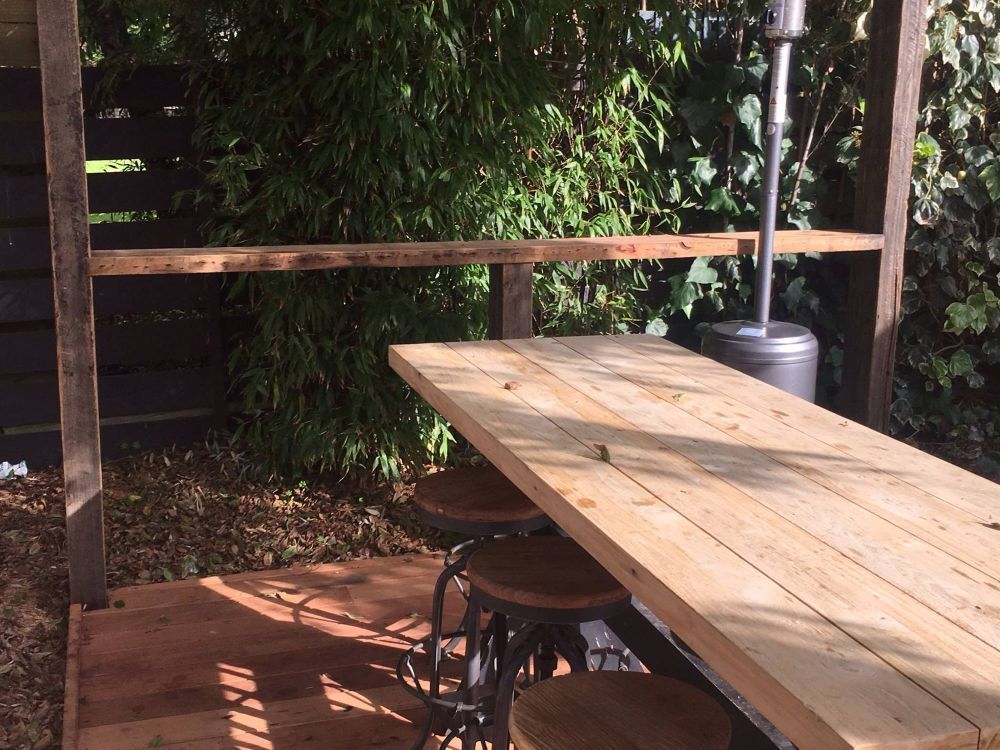 Outdoor Bar with Wooden Table, Stools, and A Heater — On The Rise Builders in Noosa, QLD