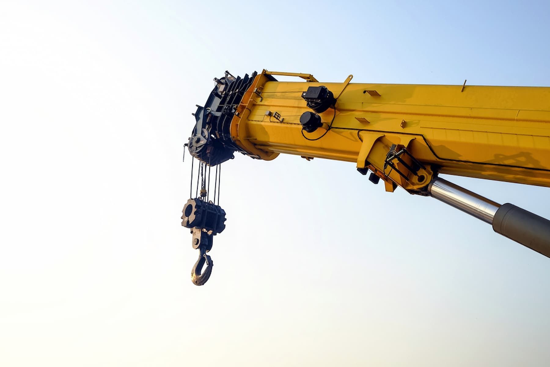A Yellow Crane with A Hook Attached to It Against a Blue Sky — D & S Crane Hire & Rigging In Maroochydore, QLD
