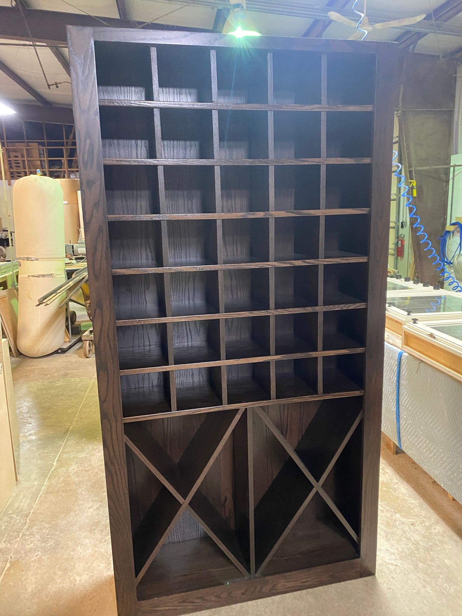 A large wooden wine rack is sitting in a warehouse.