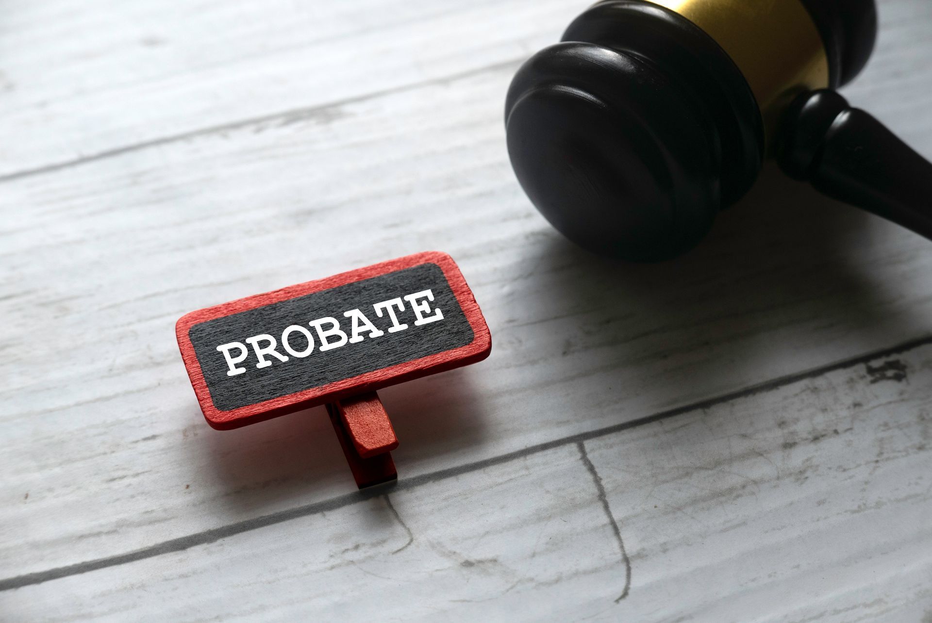 Small probate sign placed beside a judge’s gavel on a light wooden surface Small probate sign placed beside a judge’s gavel on a light wooden surface