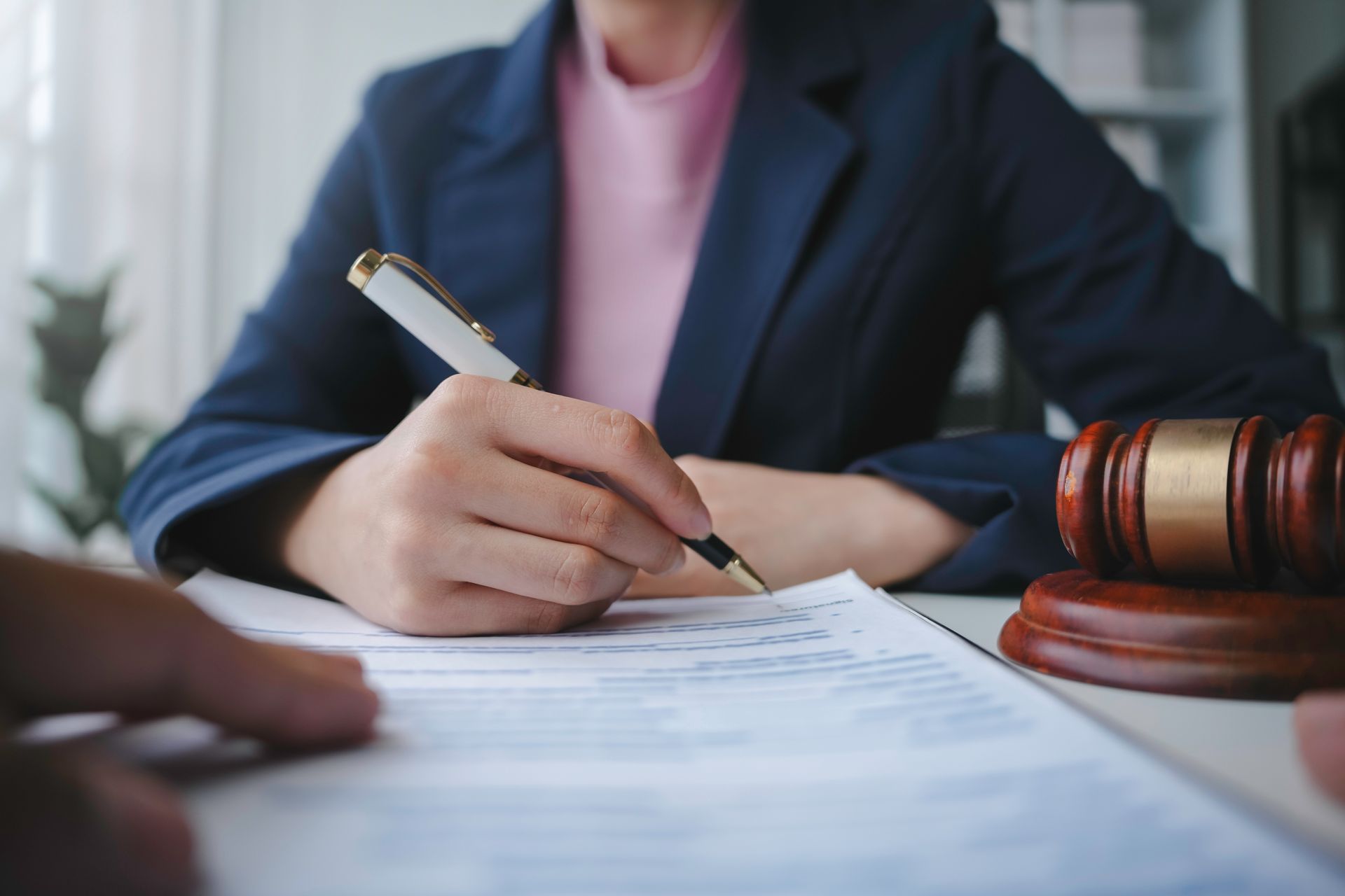 Lawyer is signing a last will and testament during a meeting with a client in their office. Lawyer is signing a last will and testament during a meeting with a client in their office.