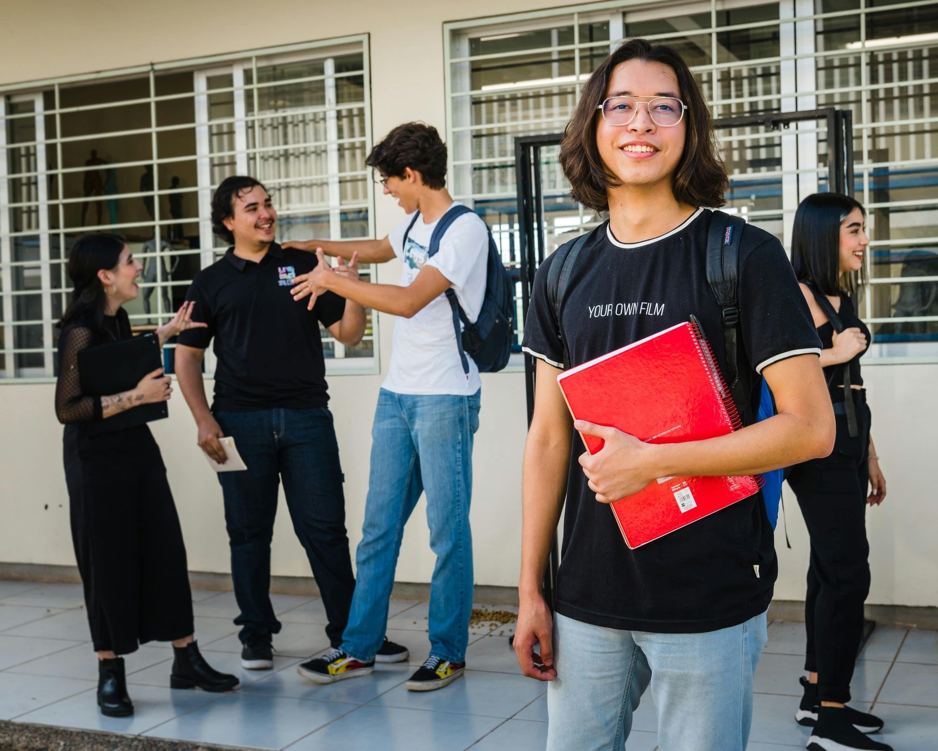 A group of young people are standing outside of a building.
