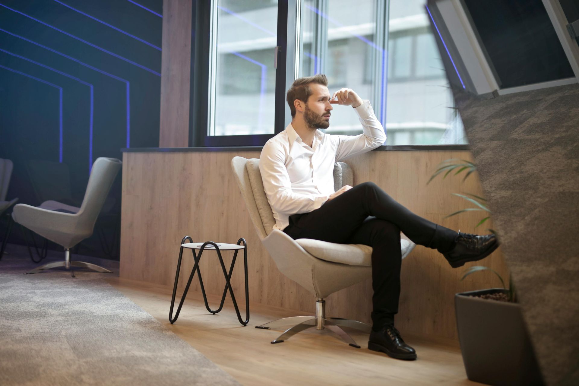 A man is sitting in a chair in front of a window.