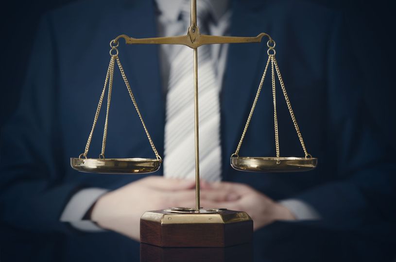 a man in a suit and tie is holding a scale of justice