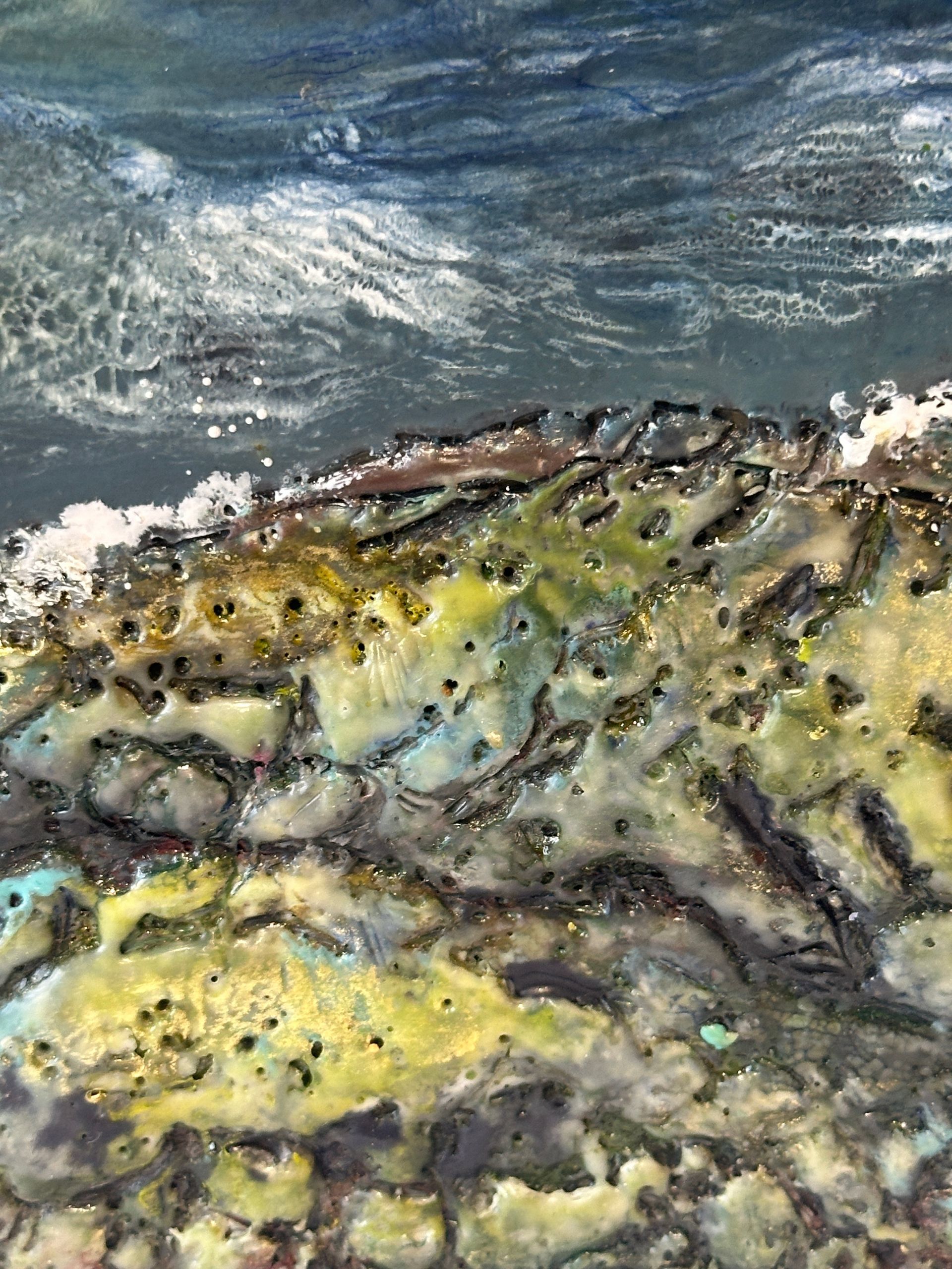A painting of a body of water with rocks in the foreground