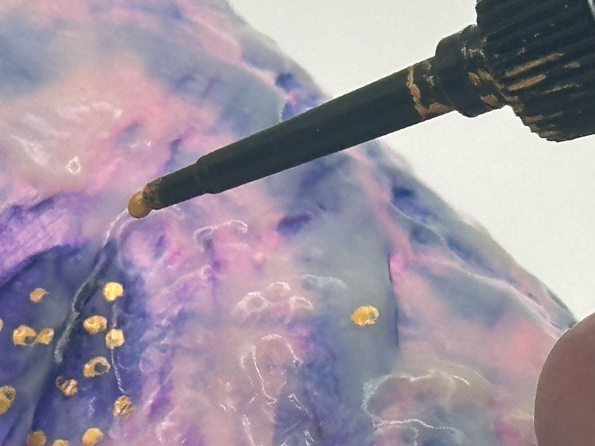 A person is pouring liquid into a purple and pink surface