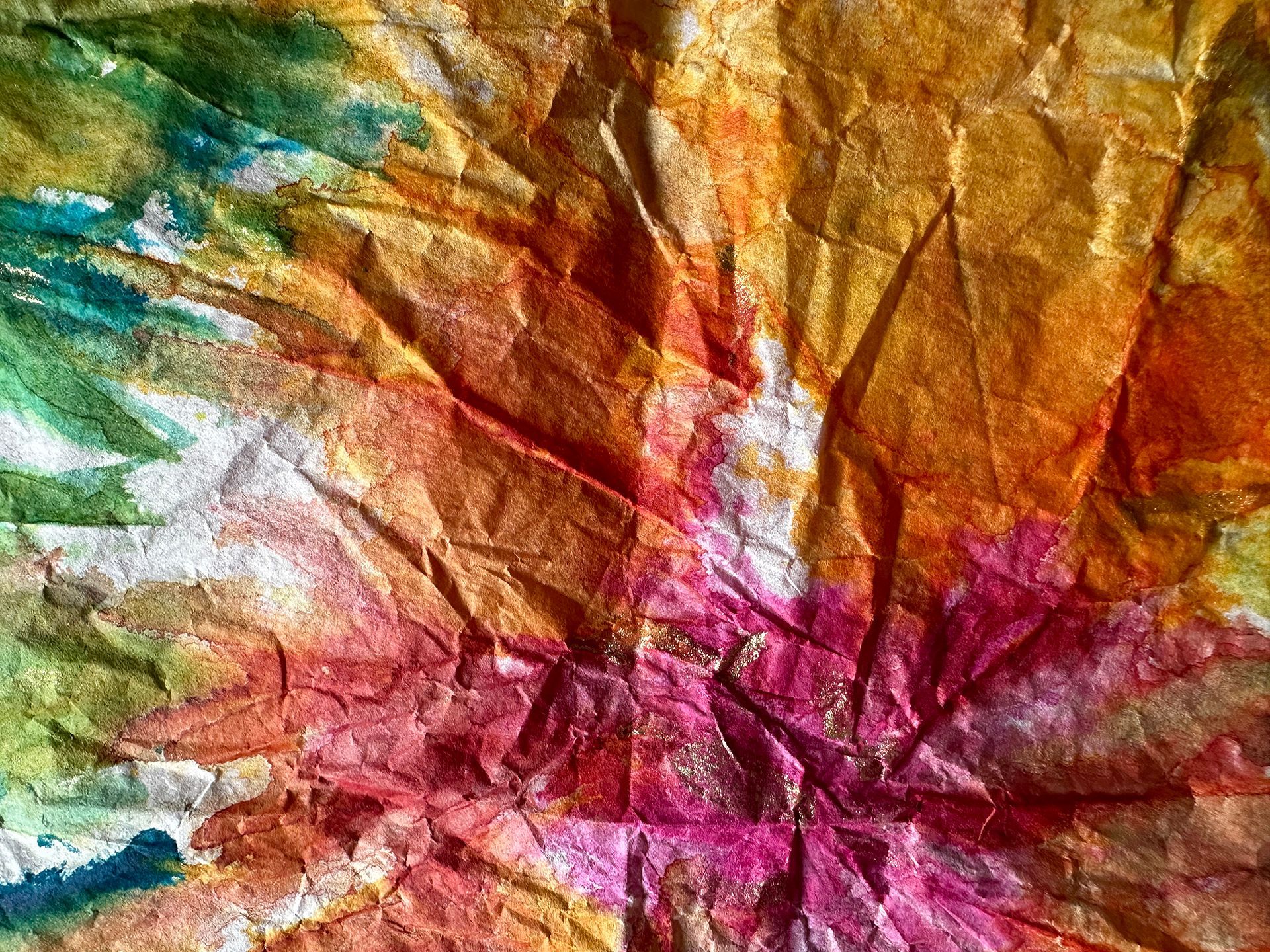 A close up of a colorful painting on a piece of crumpled paper.