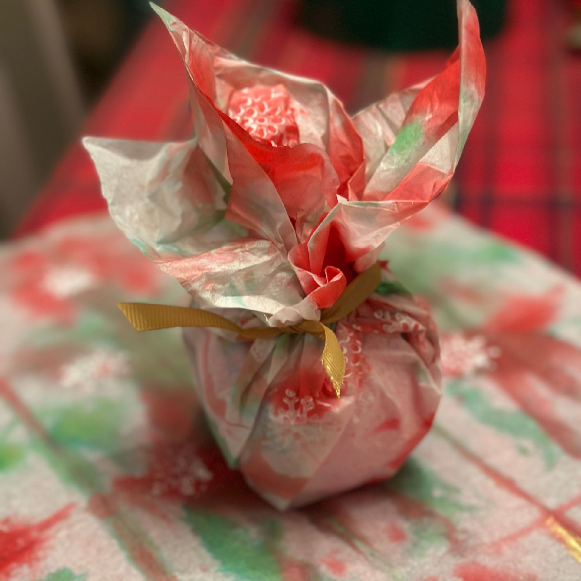 A small ball wrapped in red white and green tissue paper