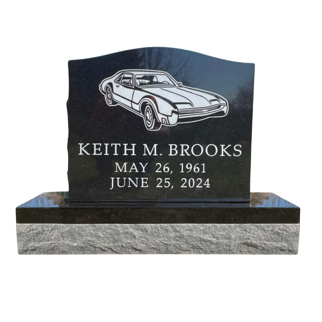 Upright monument with the image of a classic car on it.