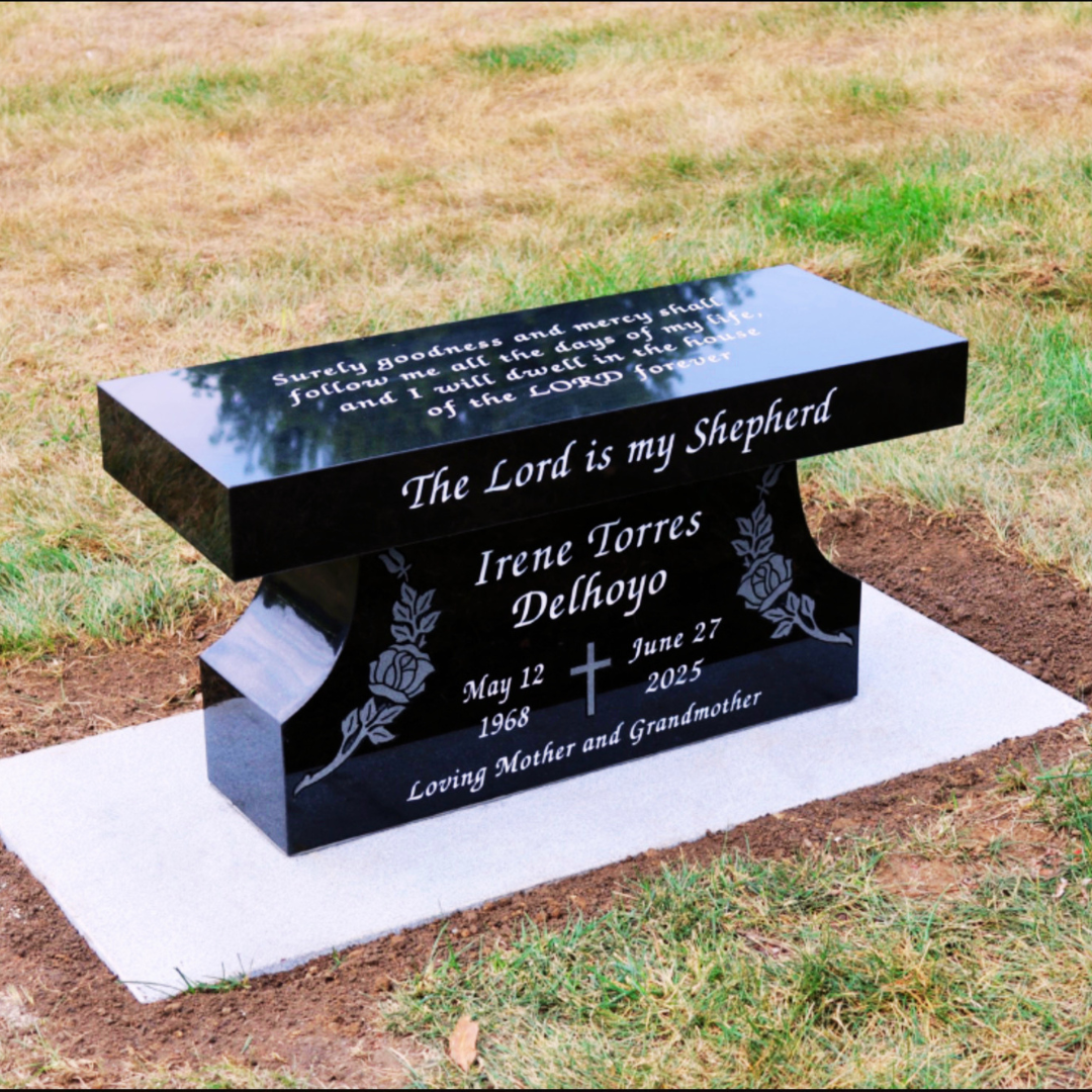 Black granite bench with engraving on the top and front sides.