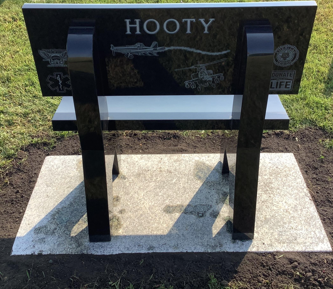 A granite memorial made in the shape of a bench with the last name Hooty engraved on the back.