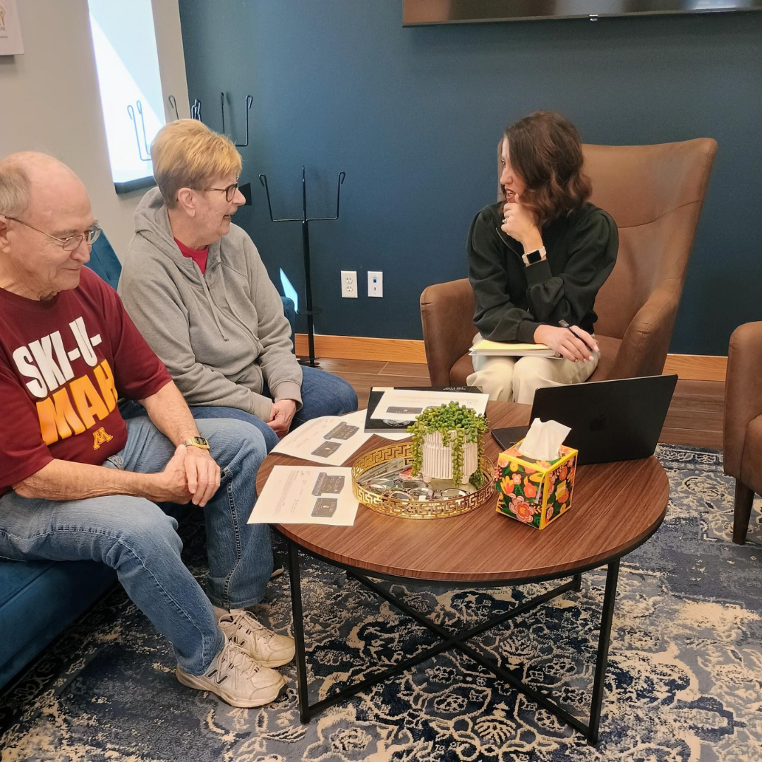 Three people in a meeting to design a cemetery monument.