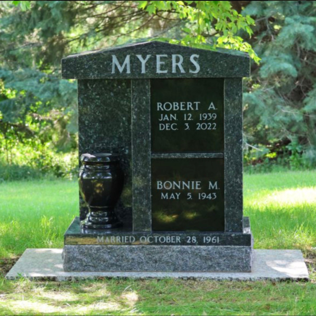 Granite cremation memorial with two niches, one above the other, and a vase.