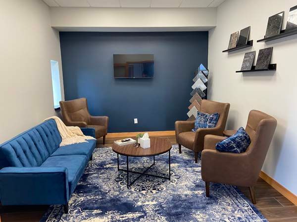 A cozy room where monument planning takes place. There is plenty of comfortable seating, sample of monuments, and a table for planning.
