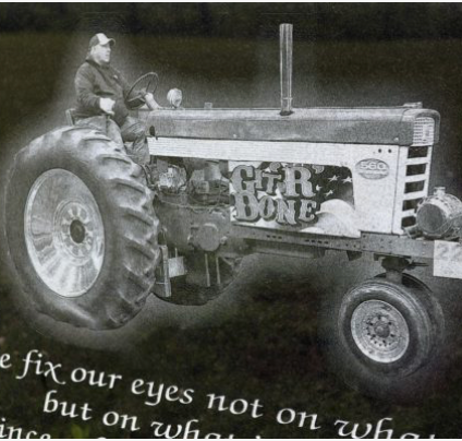 Man on tractor laser engraved onto a cemetery monument.