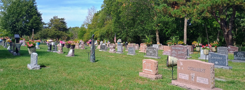 Monuments of different sizes, ages, and granite colors in a cemetery.