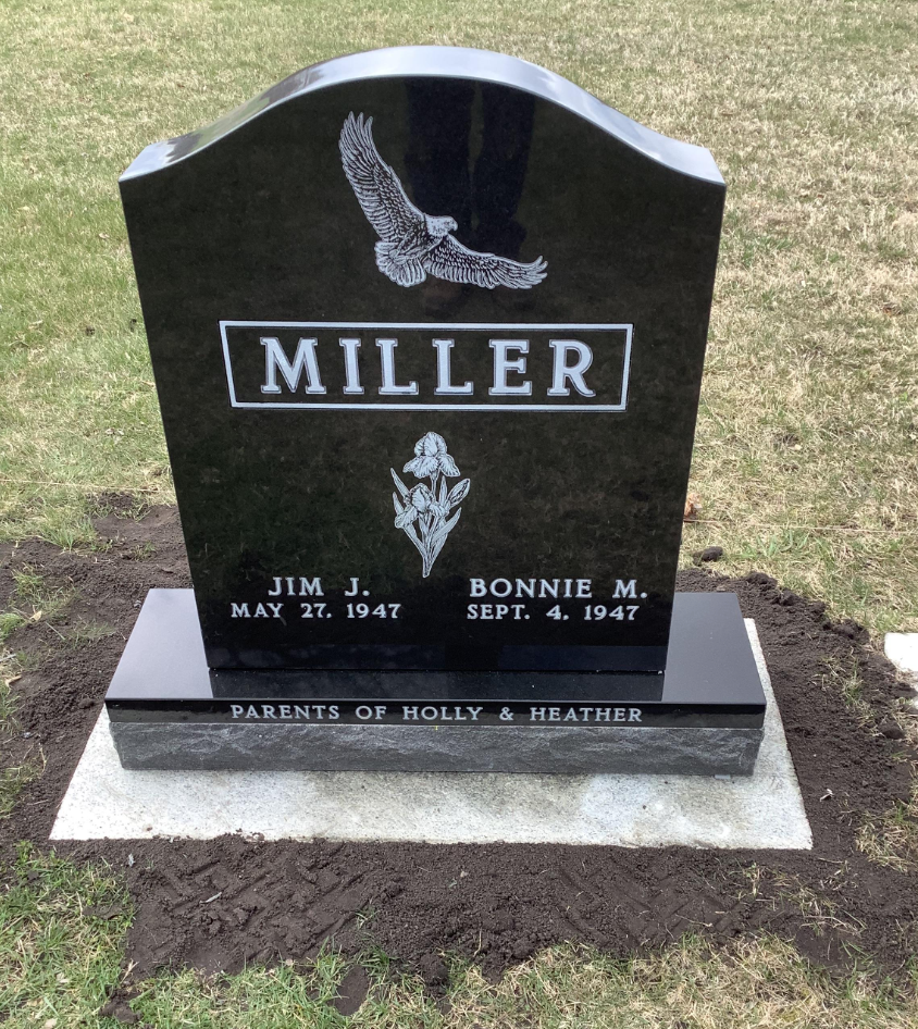 Upright monument featuring the last name, flowers, and an eagle.