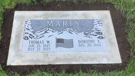 Flat marker engraved with the name Marty, made from a slab of granite and set directly into the ground. 