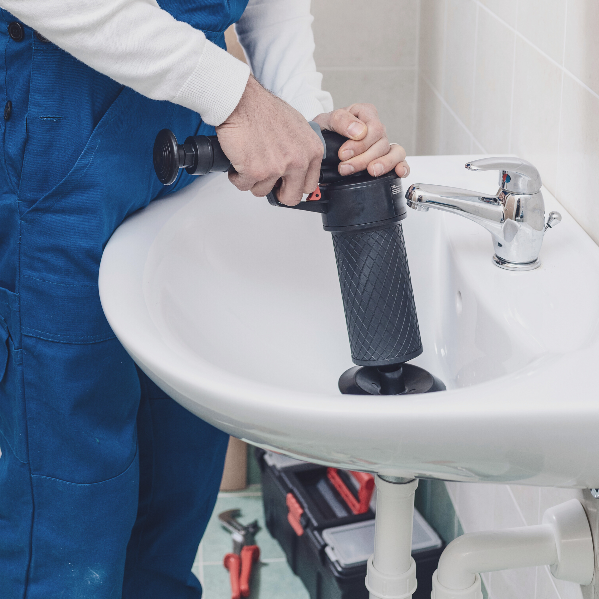 a plumber is using a plunger to unblock a sink .Dai