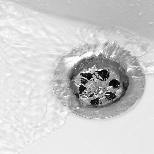 a close up of a sink drain with water running down it .