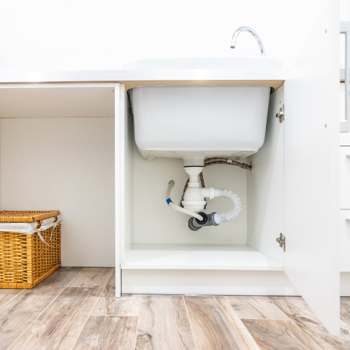 a sink is sitting under a cabinet in a kitchen .