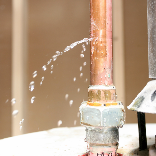 a close up of a copper pipe with water coming out of it .