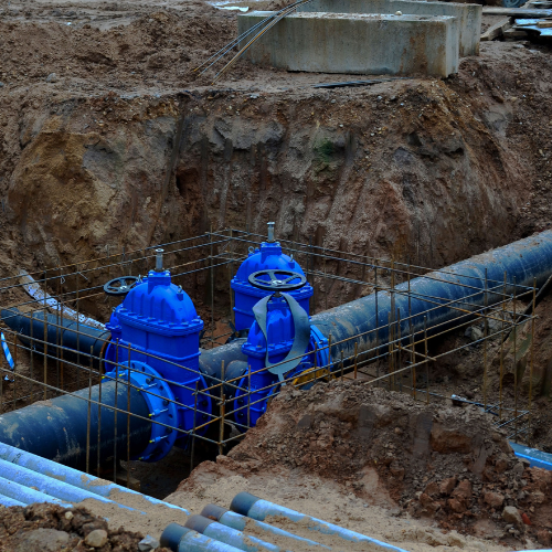 a bunch of blue pipes are laying in the dirt