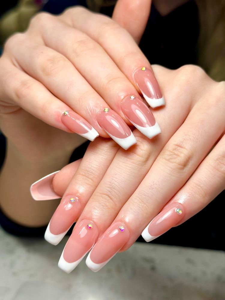 French manicure with pink-and-white nails and small rhinestone accents on clasped hands