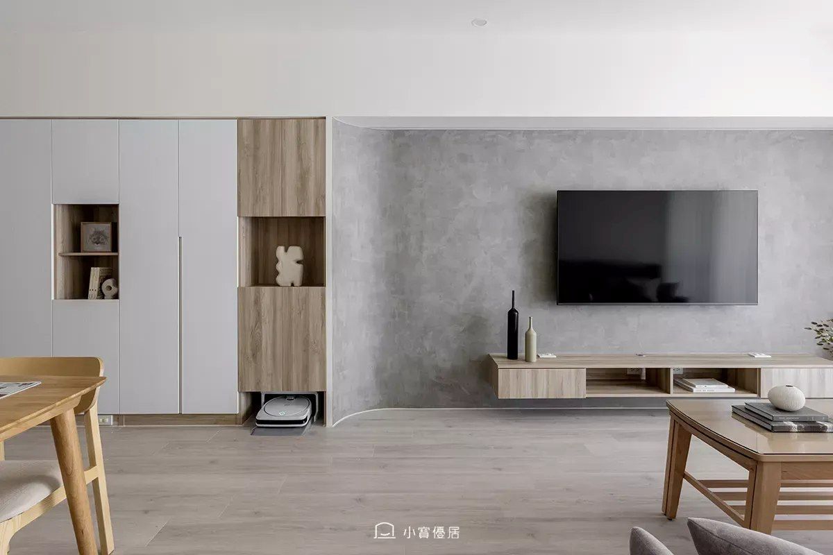 小寶優居《沐光清晨》24坪新家裝潢,木質色調搭配弧形電視牆與簡潔家具配置。